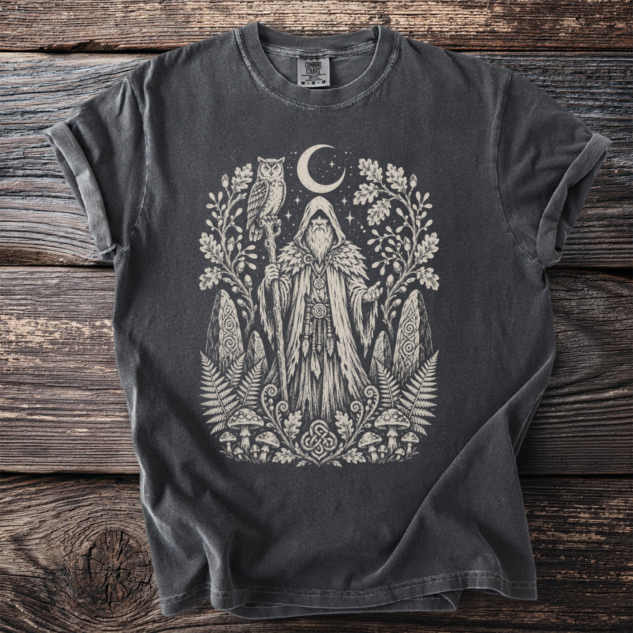 Dark grey t-shirt with a cream-colored graphic of a wizard, owl, moon, and forest elements.