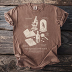 Brown t-shirt with "The Naturalist's Table" graphic and scientific illustrations.