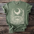Green t-shirt with a cream moon, forest, and floral design.