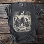 Dark t-shirt with occult scene: hooded figures, bonfire, moon, and nature elements.