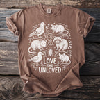 Brown t-shirt with white illustration of various animals and "Love the Unloved" text.