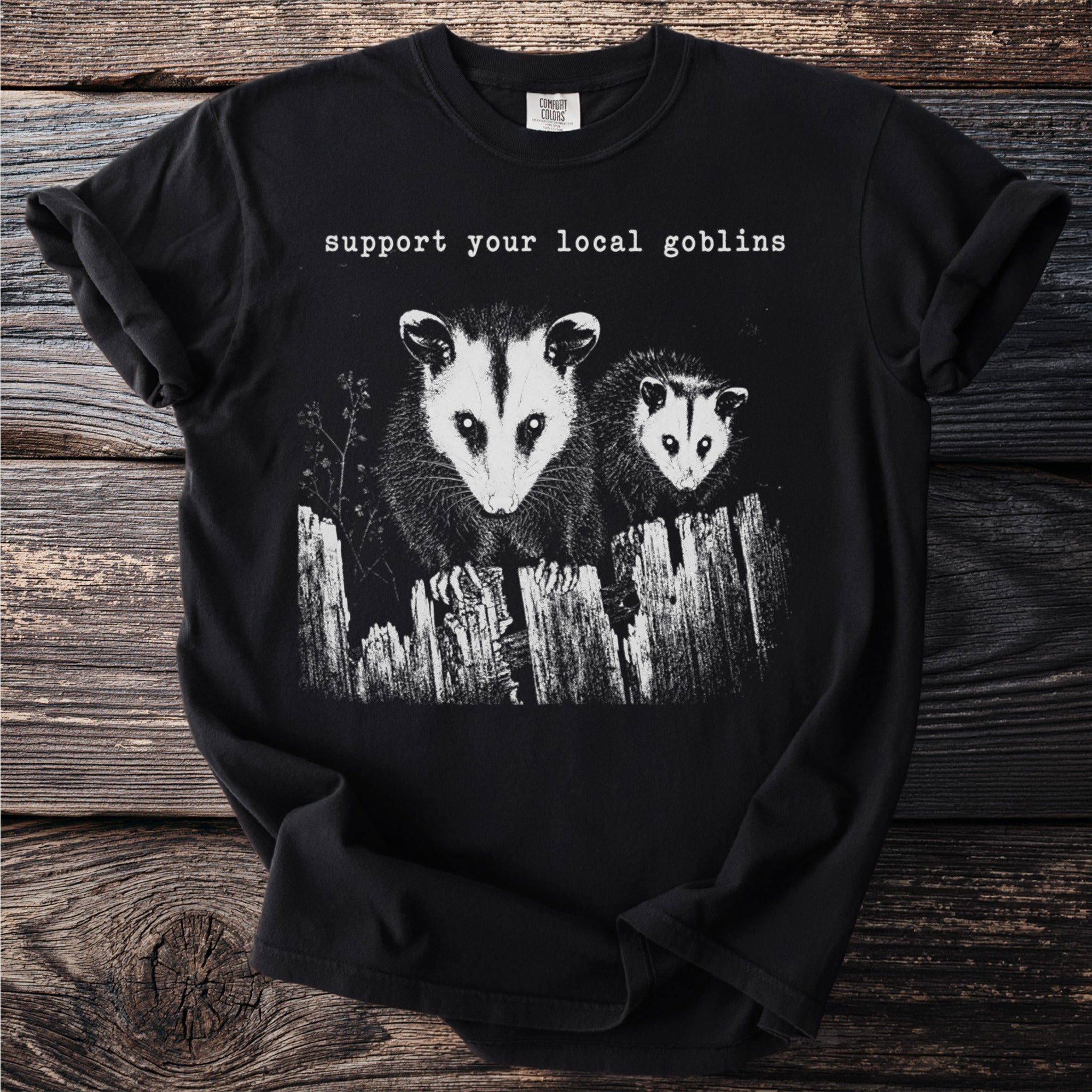 Black t-shirt with two possums and text "support your local goblins".