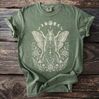 Green t-shirt with a cream moth woman, moon phases, roses, mushrooms, and ferns design.