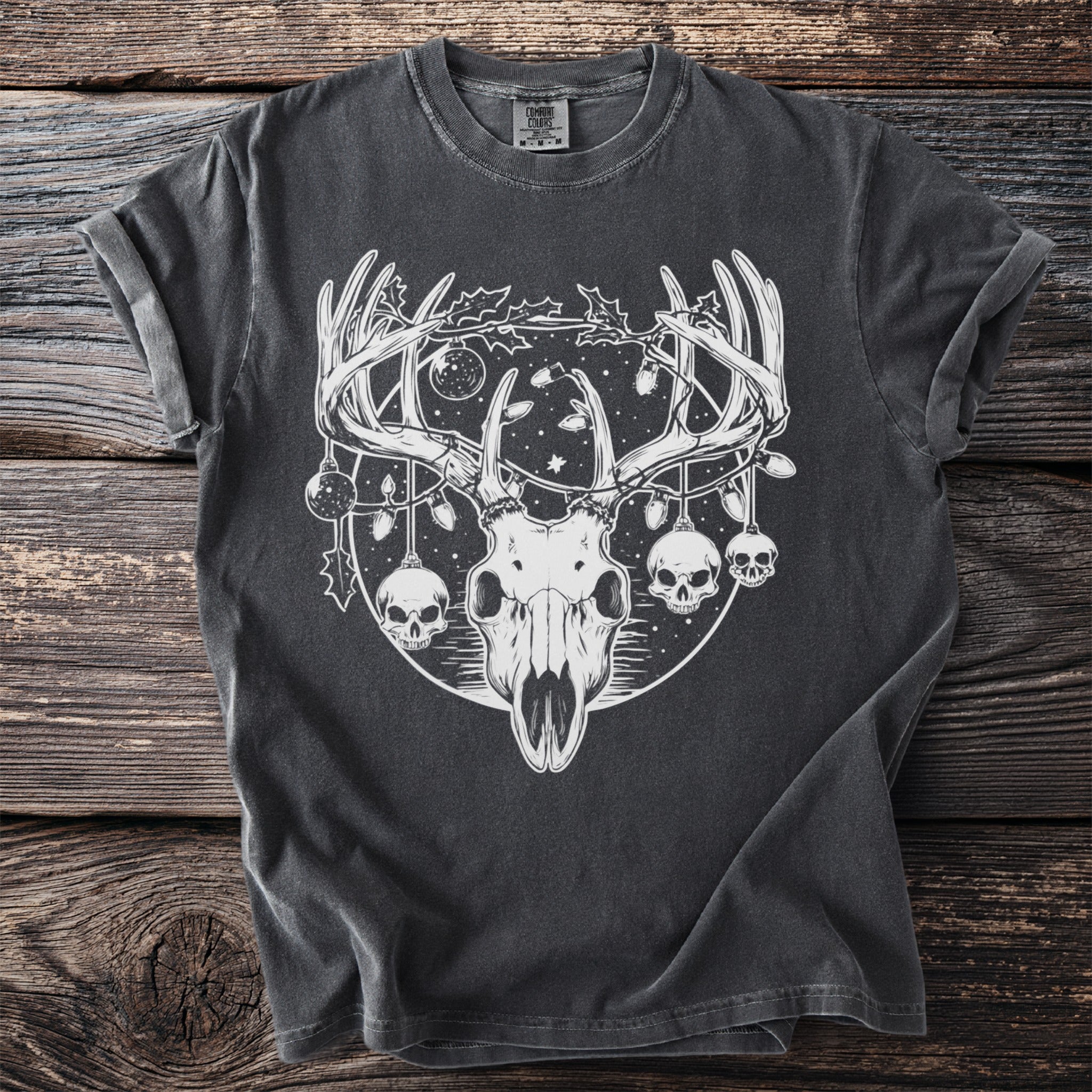 Dark t-shirt with white graphic of deer skull, antlers, skulls, and Christmas lights.