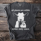 Charcoal t-shirt with a goat eating greenery and text that reads "all plants are edible some only once".