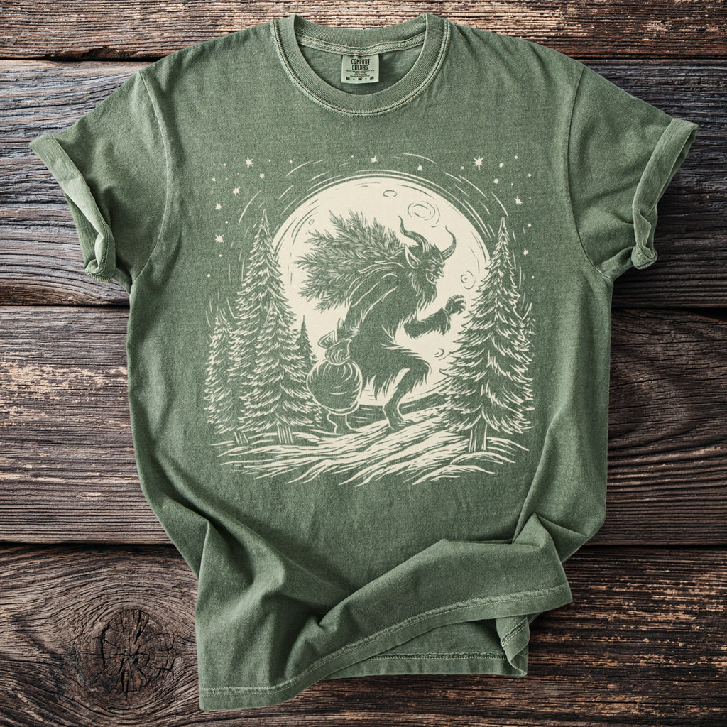 Green t-shirt with a Krampus illustration carrying a sack and branches under a moon.