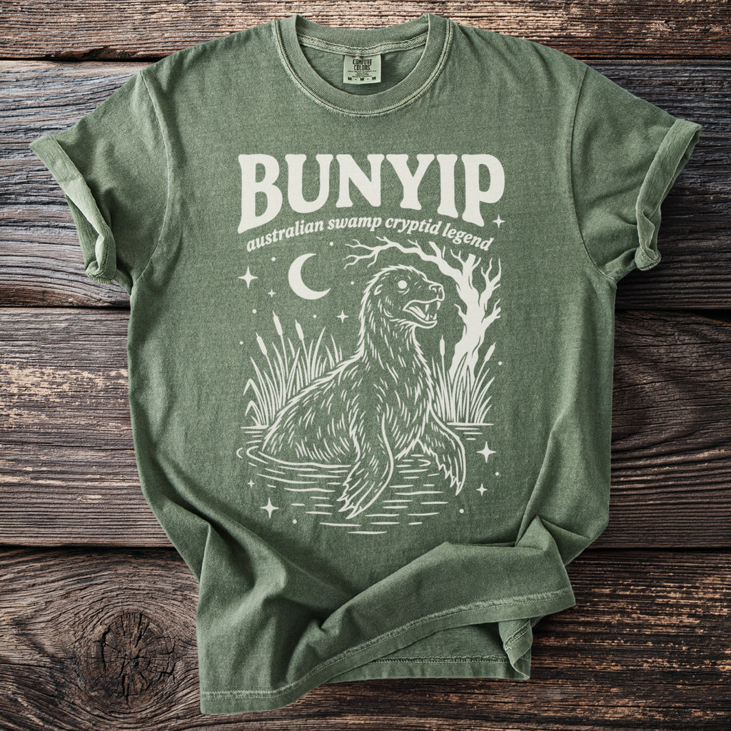 Green t-shirt with "Bunyip Australian swamp cryptid legend" text and illustration.
