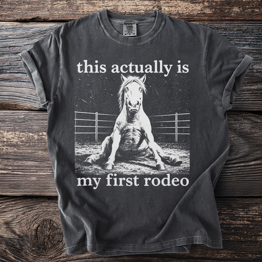Dark gray t-shirt with a horse sitting and the text "this actually is my first rodeo".