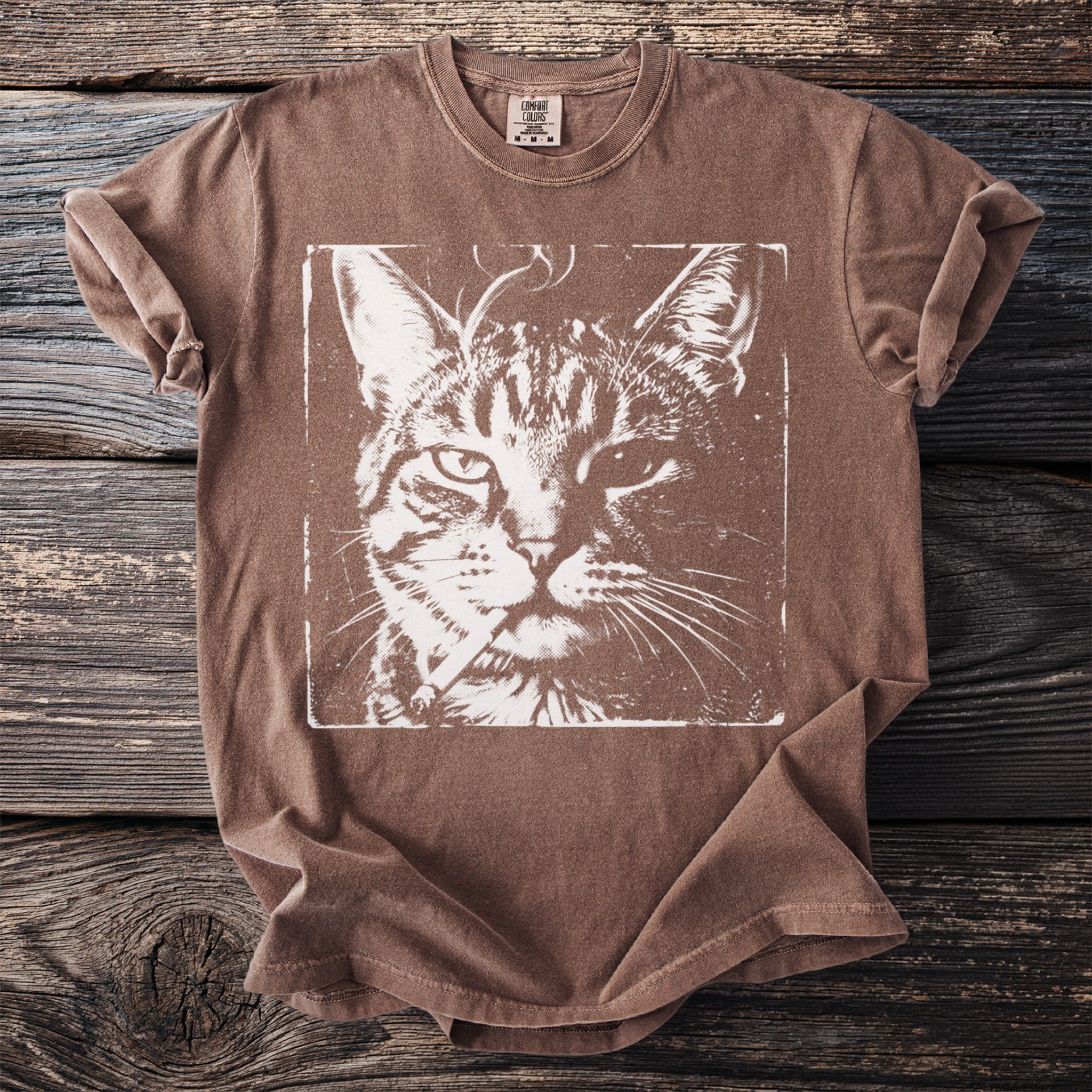Brown t-shirt with a white graphic of a cat holding a cigarette.
