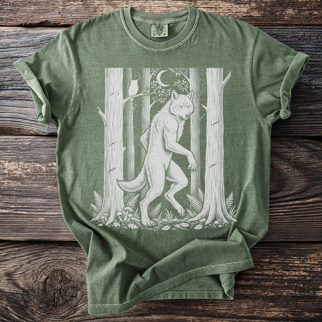 Green t-shirt with white werewolf, owl, moon, trees, and mushrooms design.