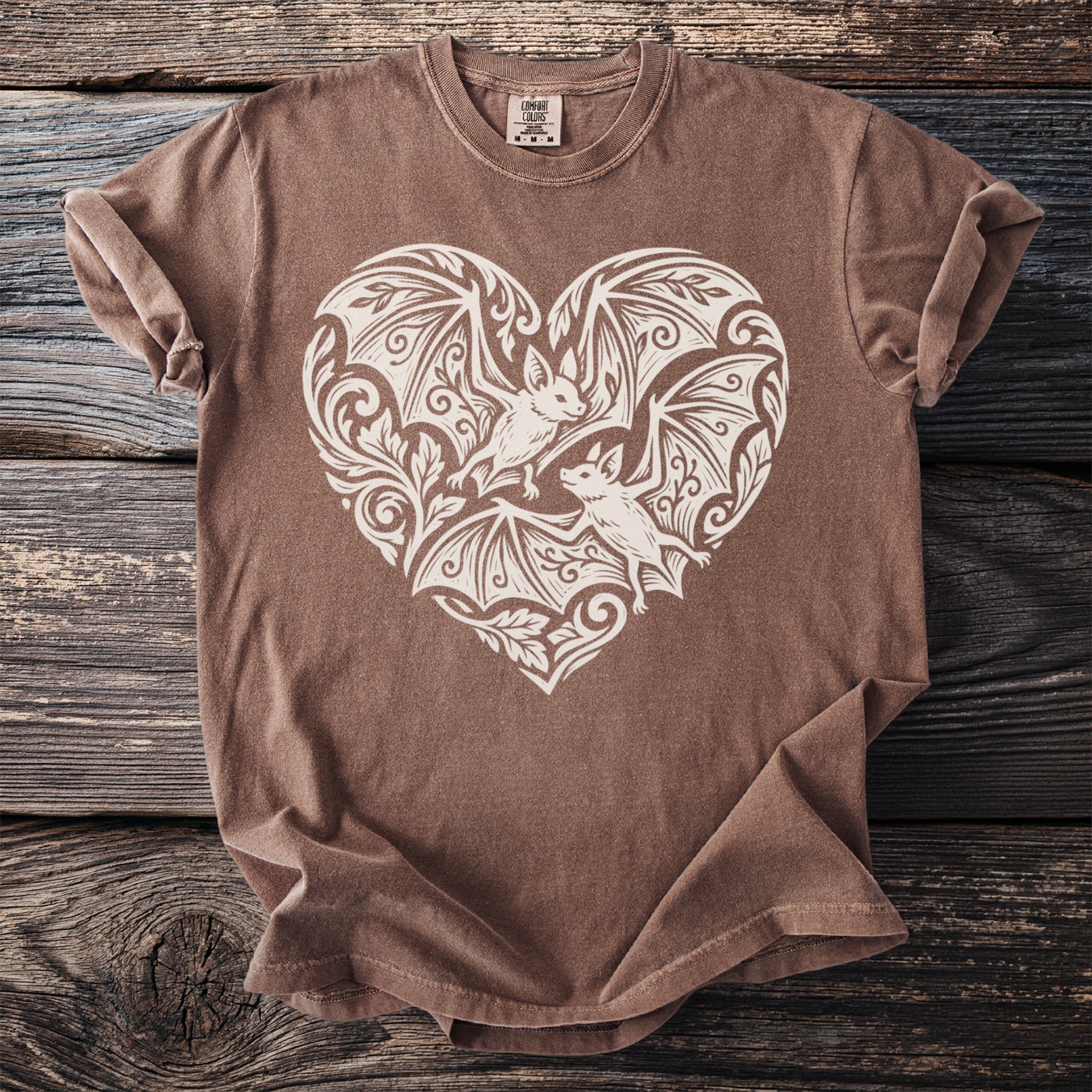 Brown t-shirt with cream heart design featuring two bats and ornate details.