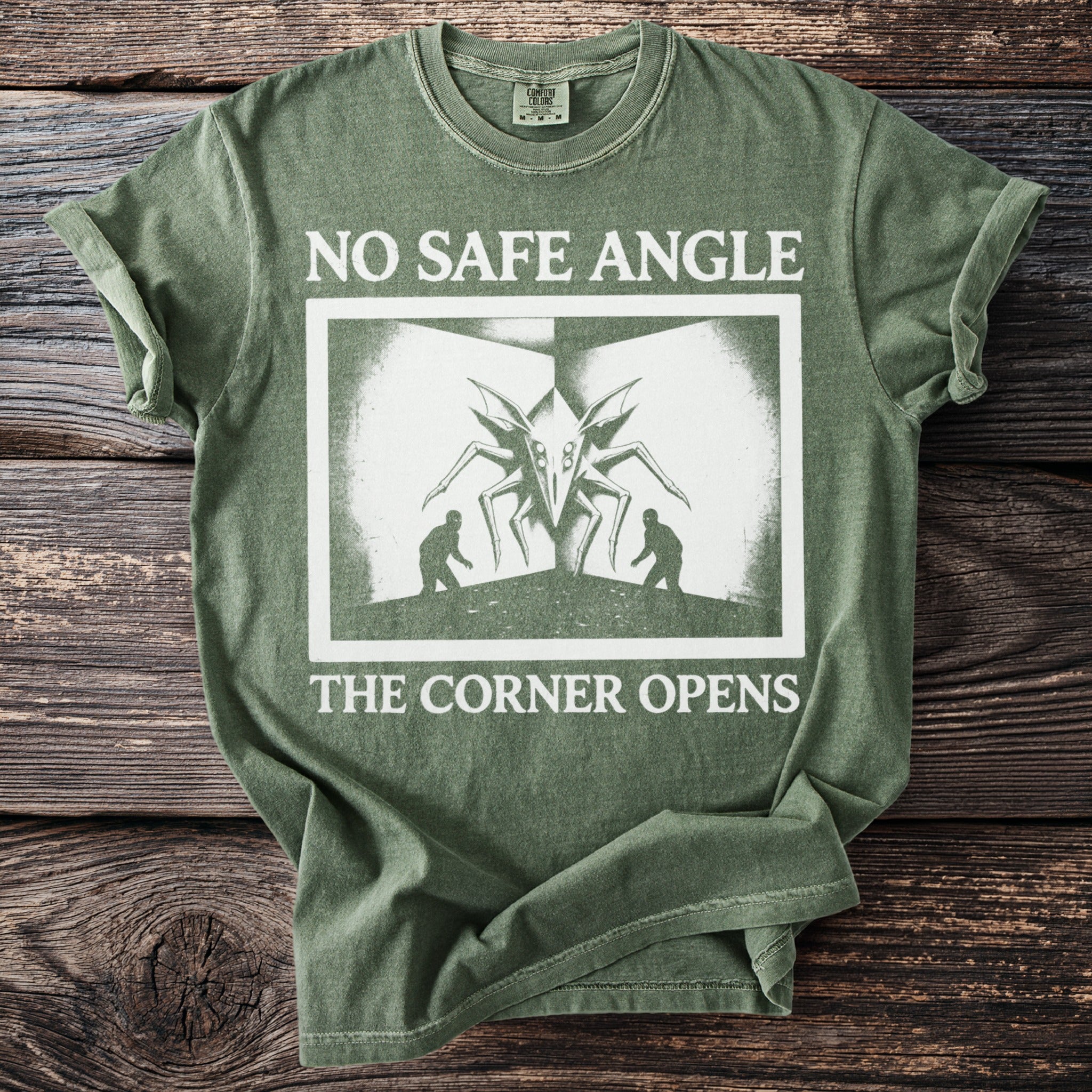 Green t-shirt with white text and graphic of a spider-like creature with two people.