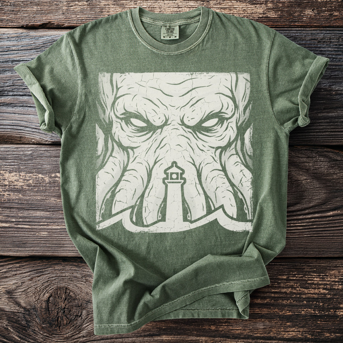 Green t-shirt with a distressed white graphic of a lighthouse and a tentacled creature.