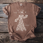 Brown t-shirt with white line art of a witch adorned with oleander and English yew.
