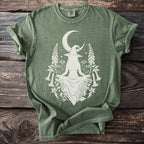 Green t-shirt with white graphic of a witch, moon, and botanical elements.