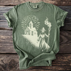 Green t-shirt with a sketch of a scarecrow, church, and bats.
