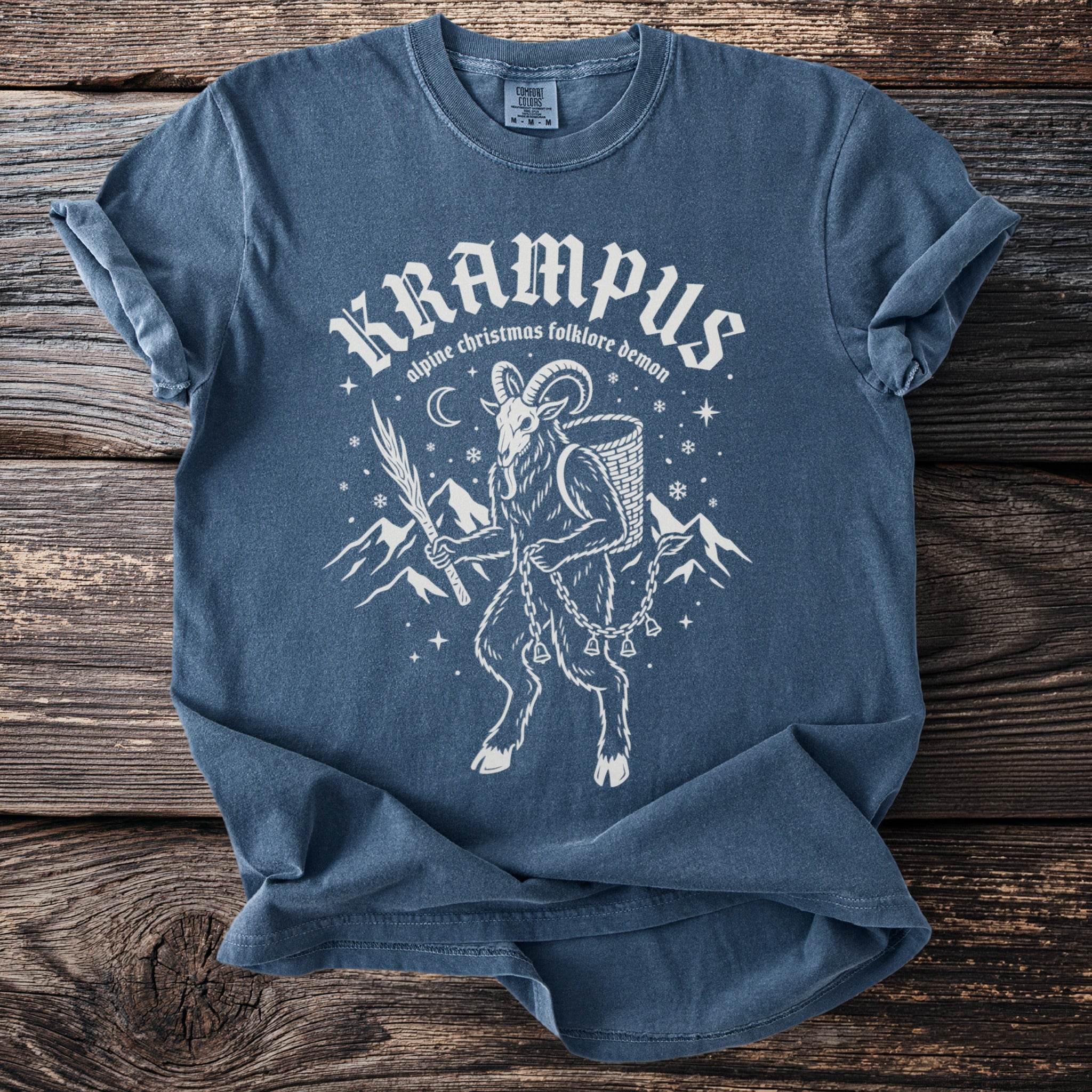 Blue t-shirt with Krampus alpine folklore demon graphic and text.