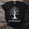 Black t-shirt with white illustration of a bare tree with skull ornaments and "Silent Night, Unholy Night" text.