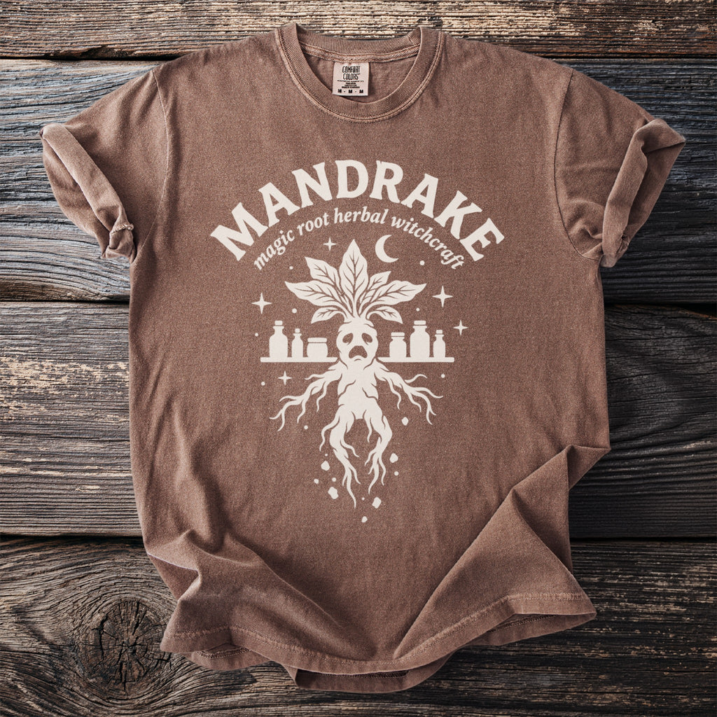 Brown t-shirt with a white mandrake graphic and text "MANDRAKE magic root herbal witchcraft".