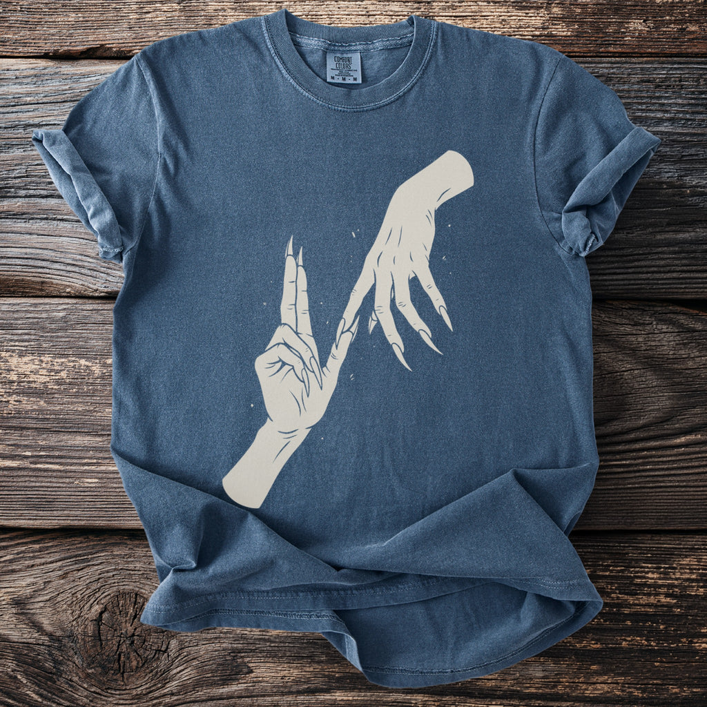 Blue t-shirt with a graphic of two stylized hands with long fingernails.