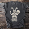 T-shirt with a light beige folk-art design of a figure holding a rattle and drum.