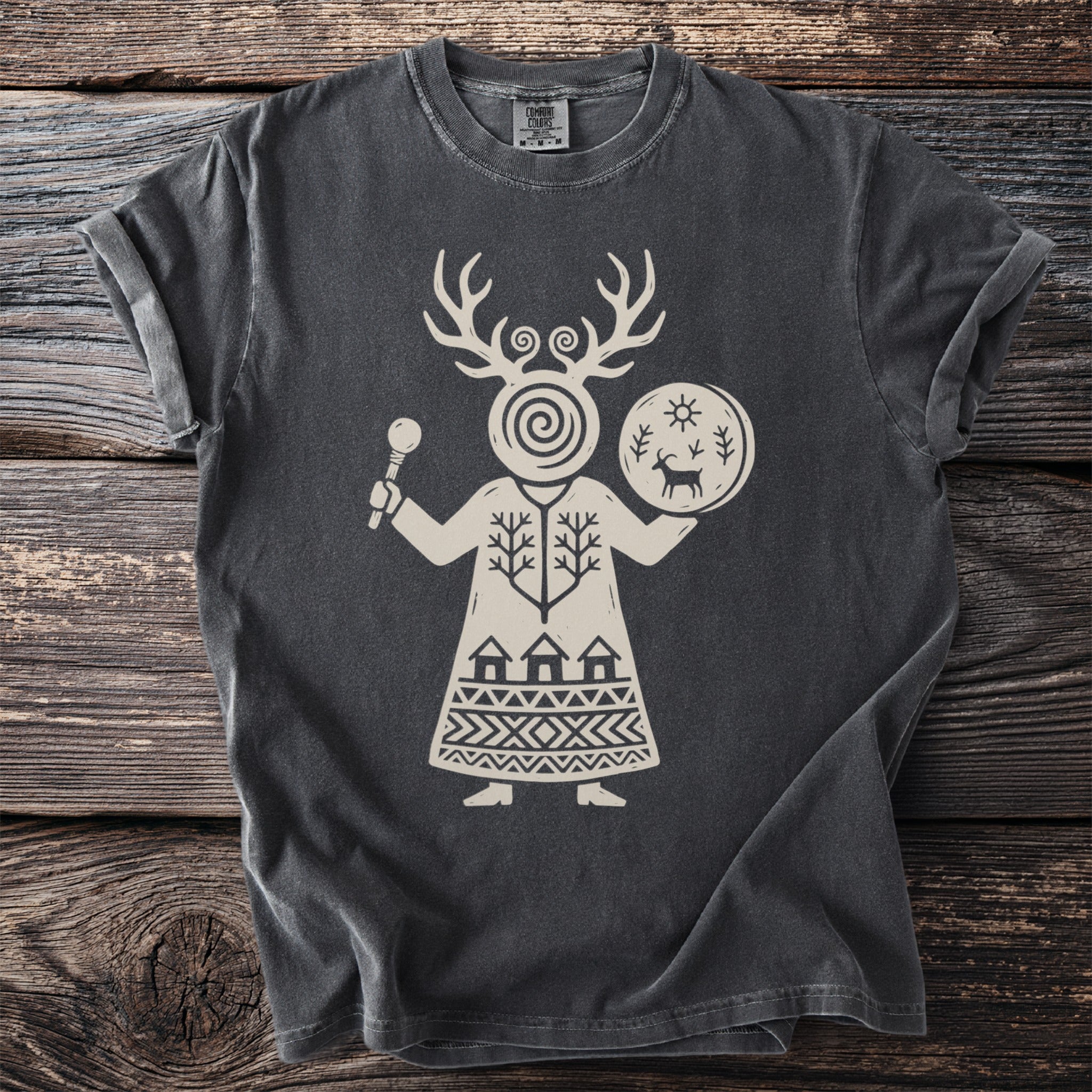 T-shirt with a light beige folk-art design of a figure holding a rattle and drum.