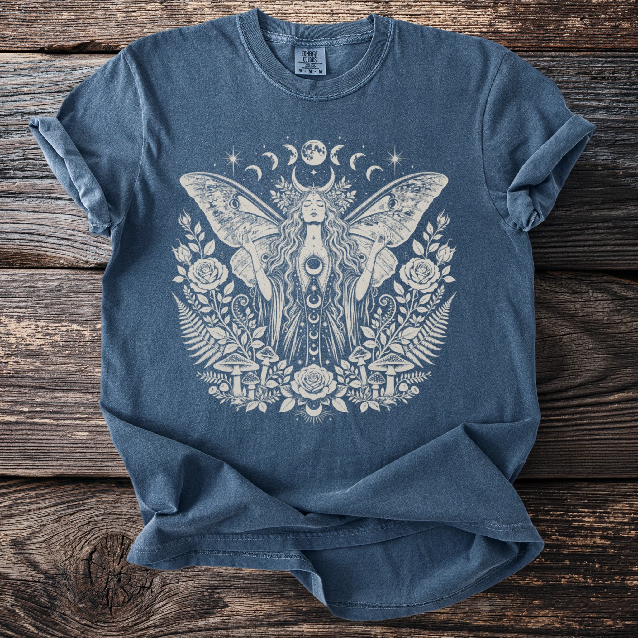 Blue t-shirt with distressed print of a celestial woman with moth wings and floral elements.