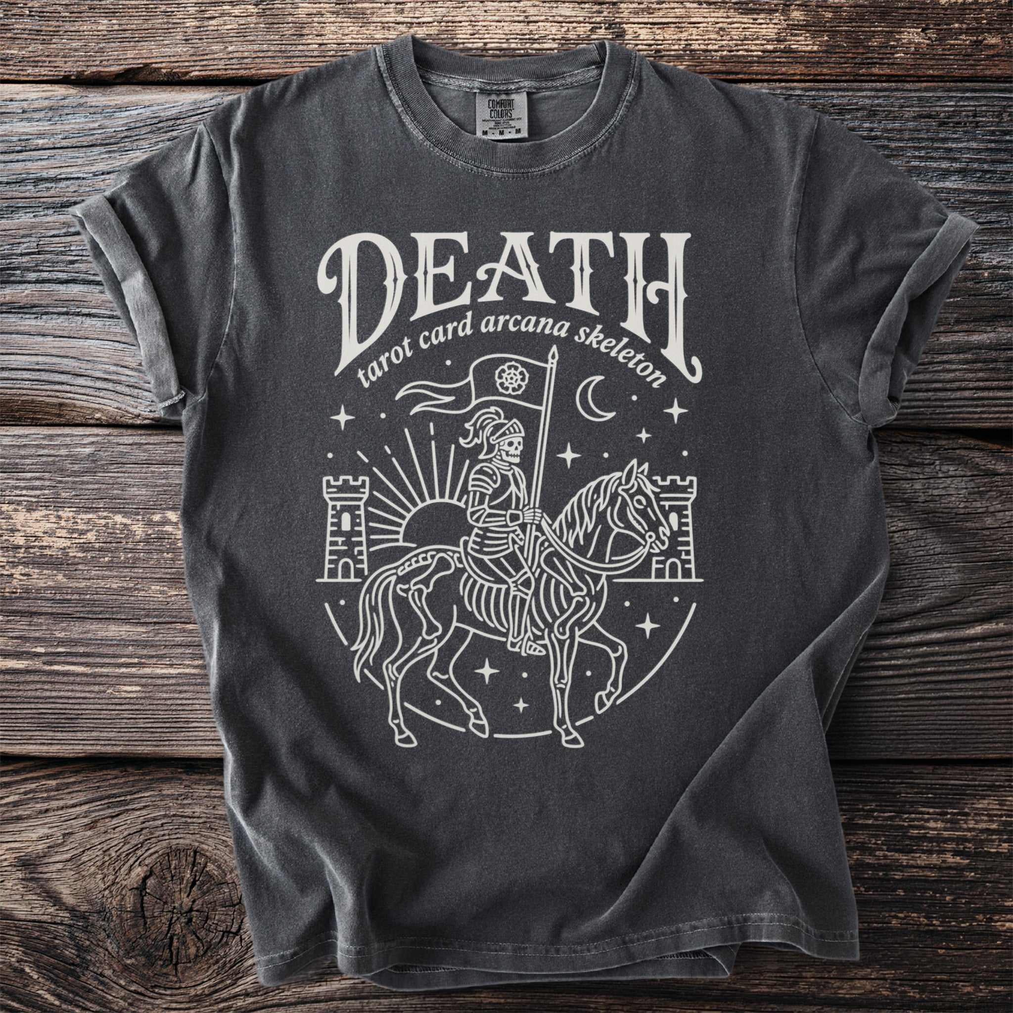 Dark gray t-shirt with white outline graphic of skeleton on horse, holding flag, with castles and sun.