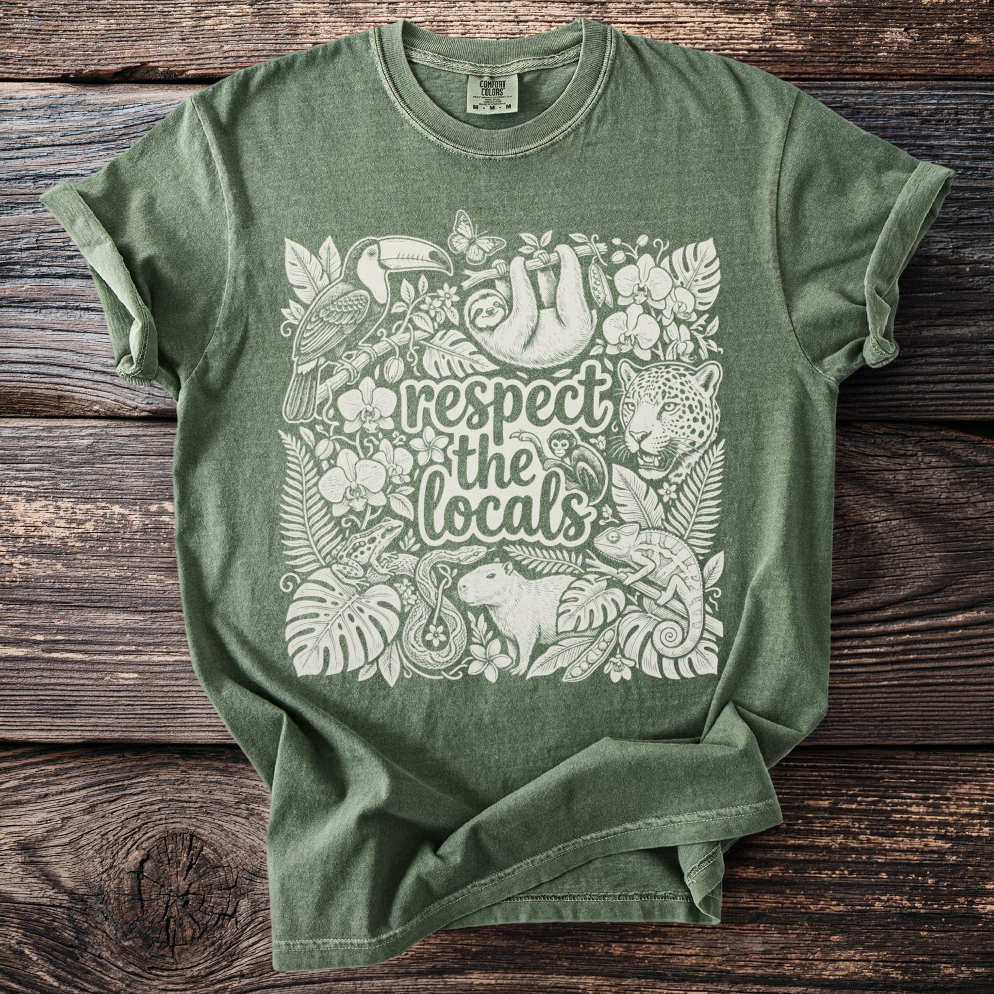 Green t-shirt with white illustration of rainforest animals and text "respect the locals".