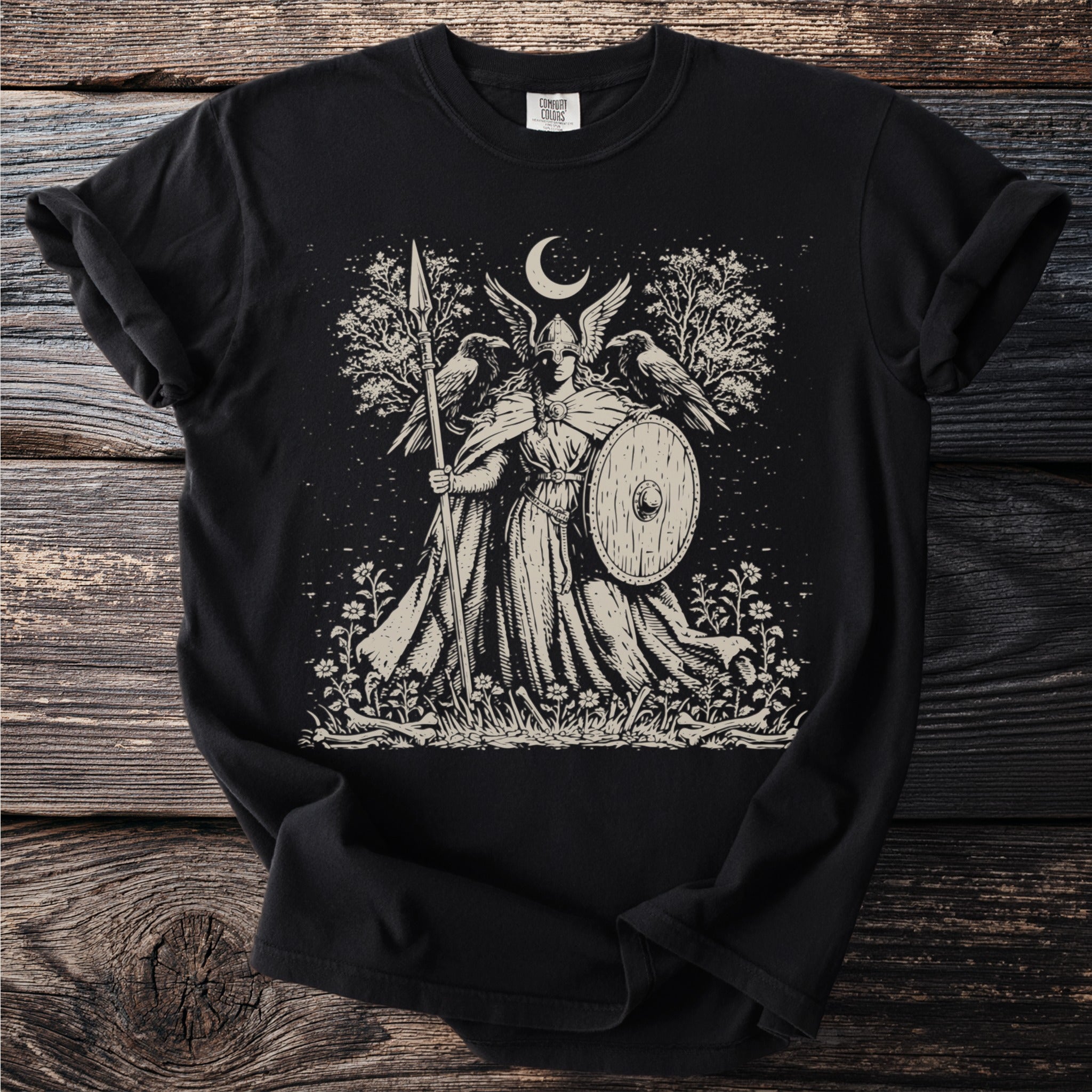 Valkyrie with shield and spear, two ravens, trees, moon, and flowers.