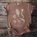 Brown t-shirt with "The Living Light" text and detailed bioluminescent sea creature illustrations.