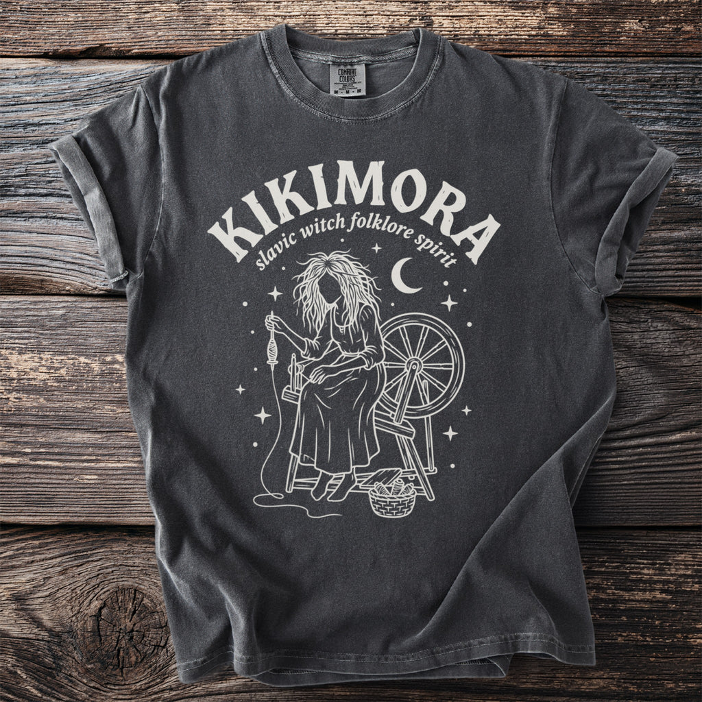 Dark gray Comfort Colors t-shirt with Kikimora slavic folklore spirit design.