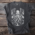 Dark grey t-shirt with a white graphic of a tentacled creature over a lighthouse.