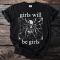 Black t-shirt with a spider on a web and text "girls will be girls".