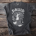 Dark grey t-shirt with white druid graphic on a tree with cows and book.