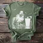 Olive green Comfort Colors t-shirt with graphic of a pigeon and a coffee cup.
