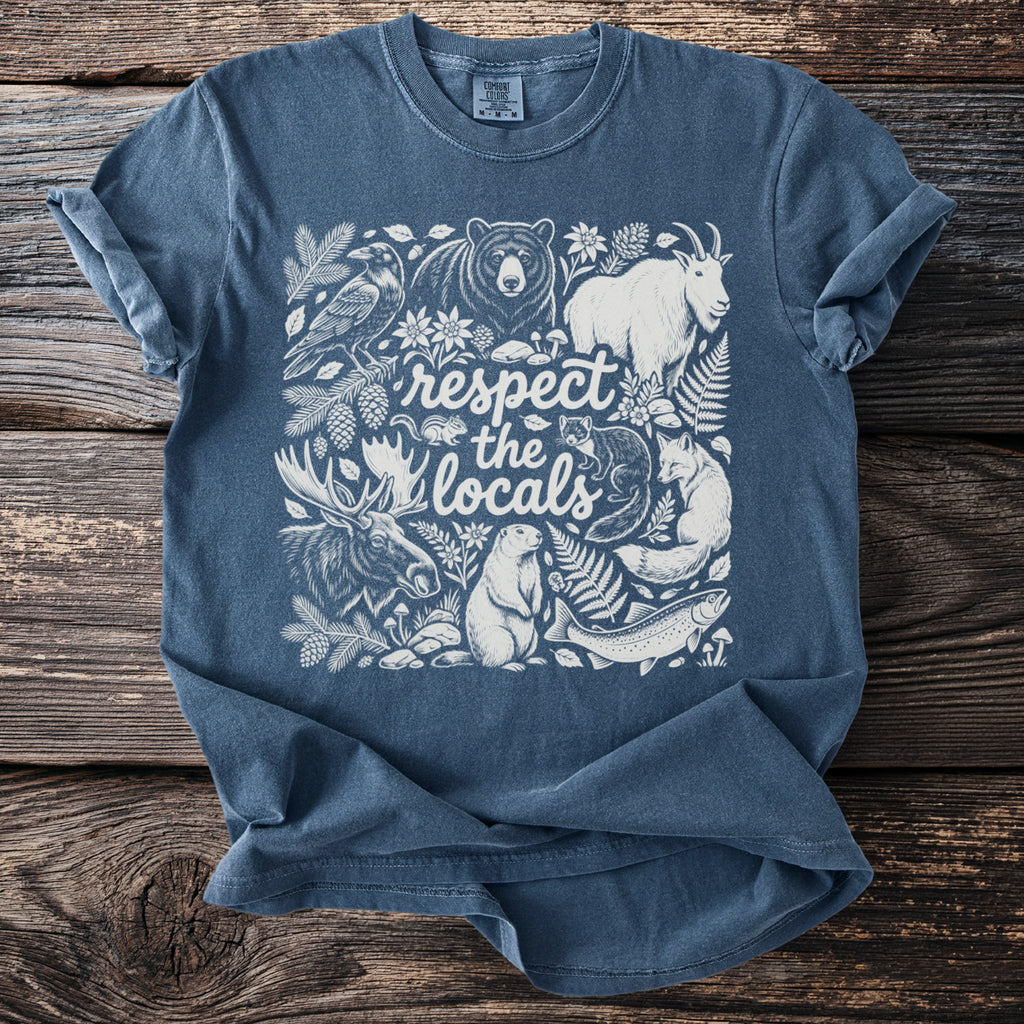 Blue t-shirt with a white line-art graphic of woodland animals and text "respect the locals."