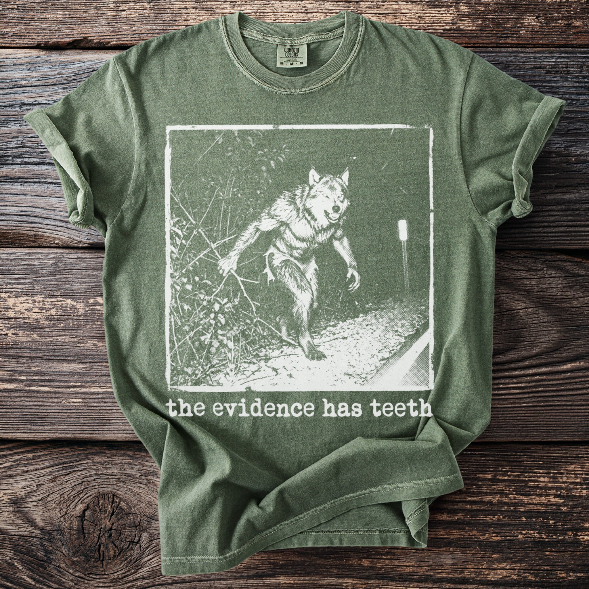 Green t-shirt with a werewolf graphic and the text "the evidence has teeth."