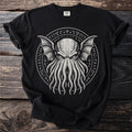 Black t-shirt with a white circular graphic of a creature with tentacles and wings.