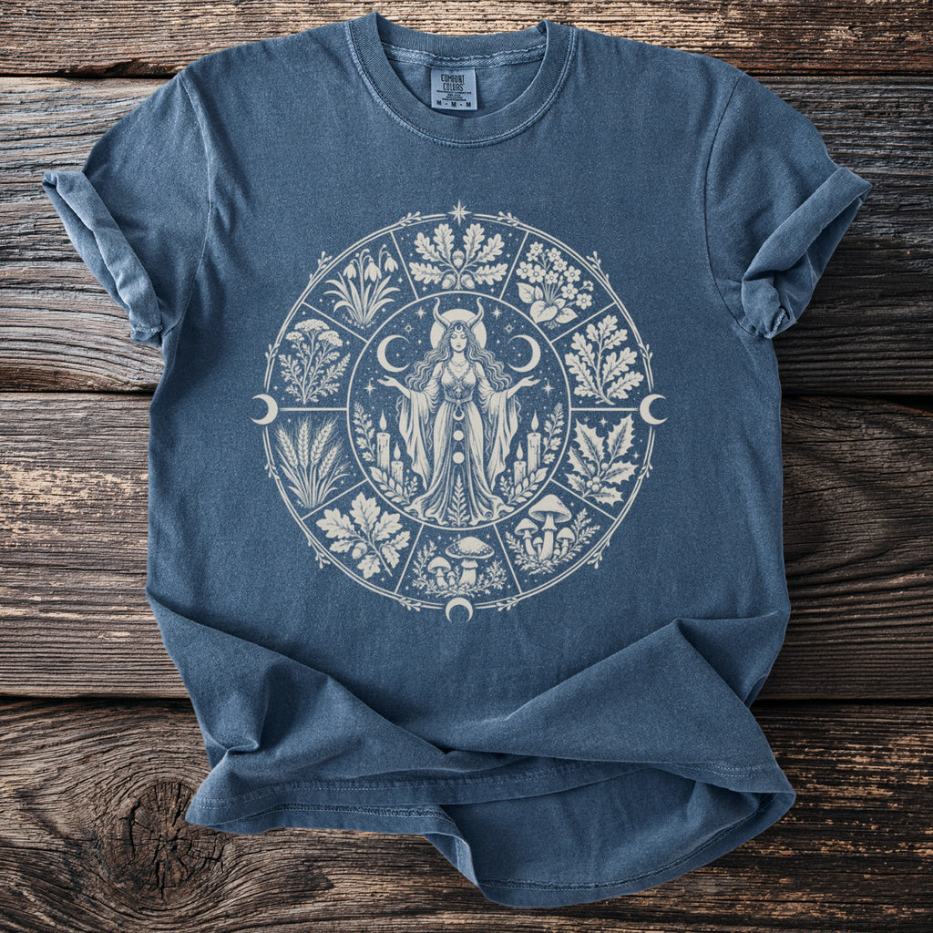 Blue t-shirt with a circular pagan-themed graphic featuring a woman, plants, and celestial symbols.