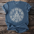 Blue t-shirt with a circular pagan-themed graphic featuring a woman, plants, and celestial symbols.