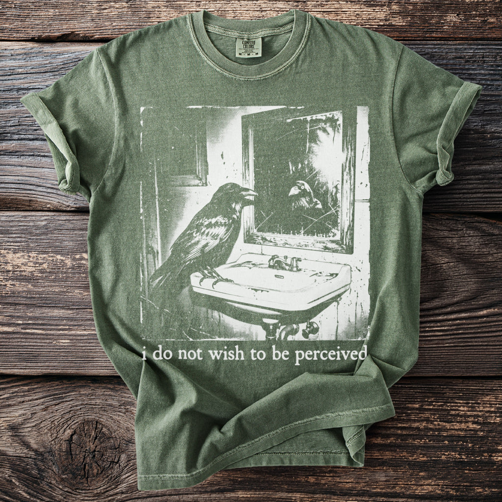 Green t-shirt with a raven at a sink and the text "i do not wish to be perceived".