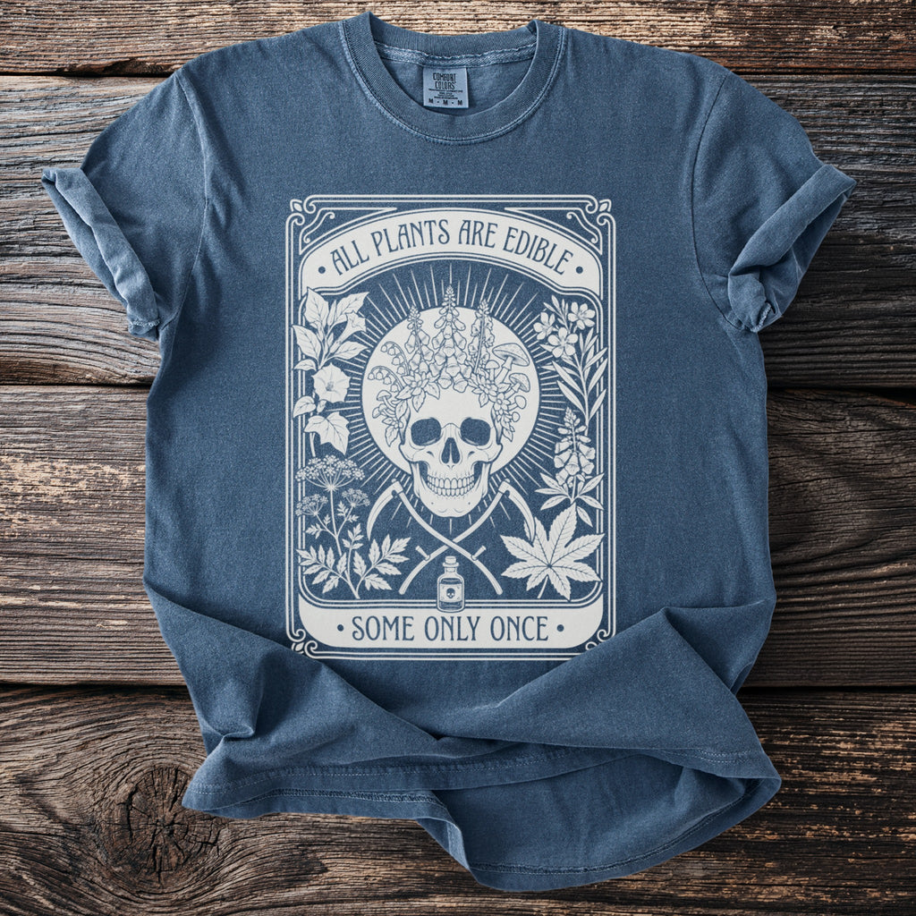 Blue t-shirt with skull, plants, and text "All plants are edible. Some only once."
