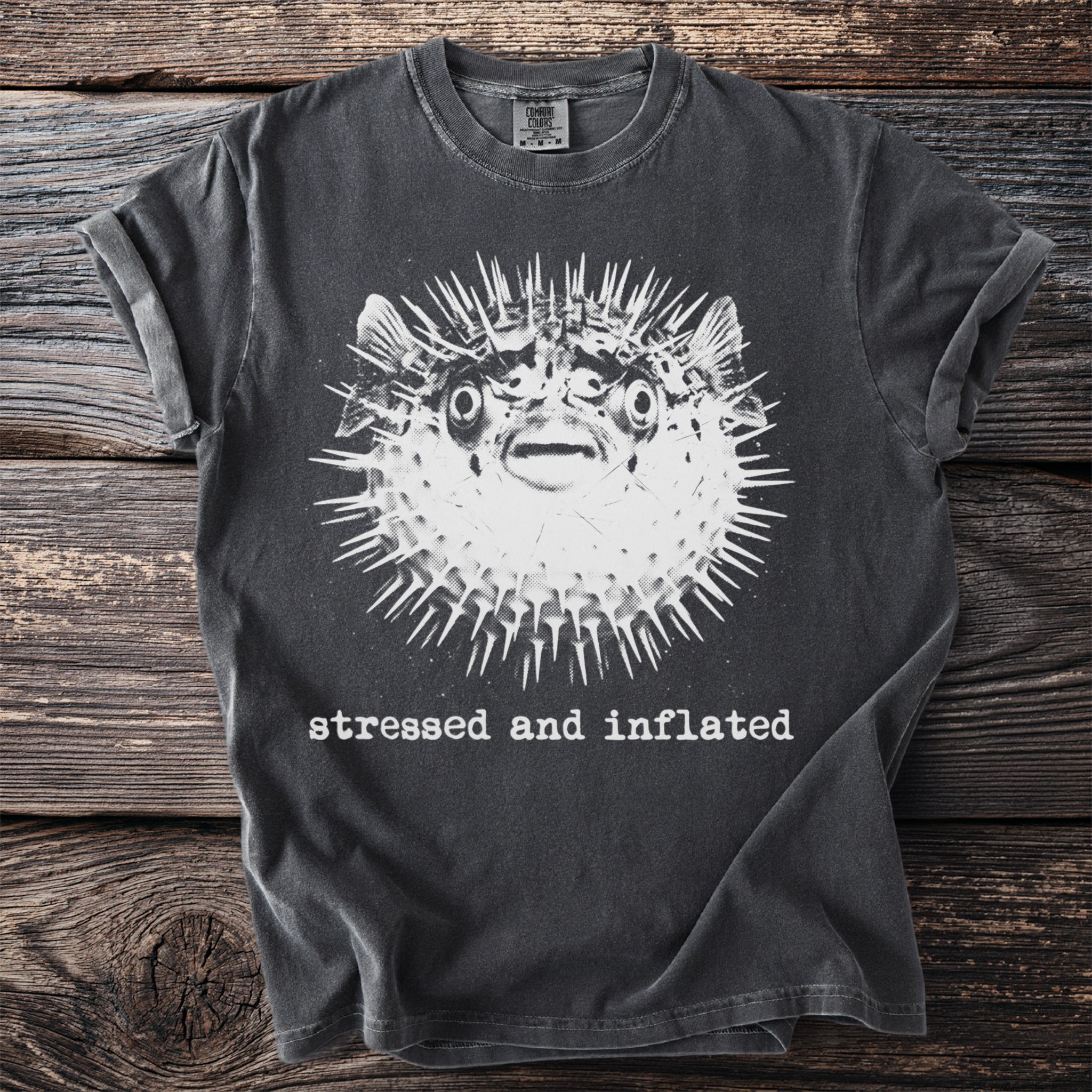 Charcoal t-shirt with a graphic of a pufferfish and the text "stressed and inflated".