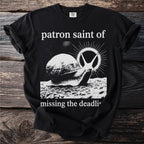 Black t-shirt with text "patron saint of missing the deadli" and a snail graphic.