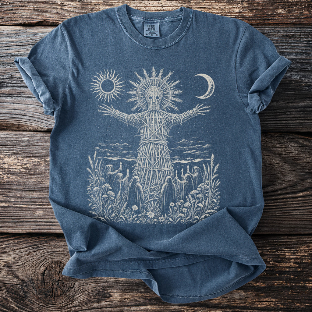 Blue t-shirt with cream print of a wicker man figure, sun, moon, and hooded figures.