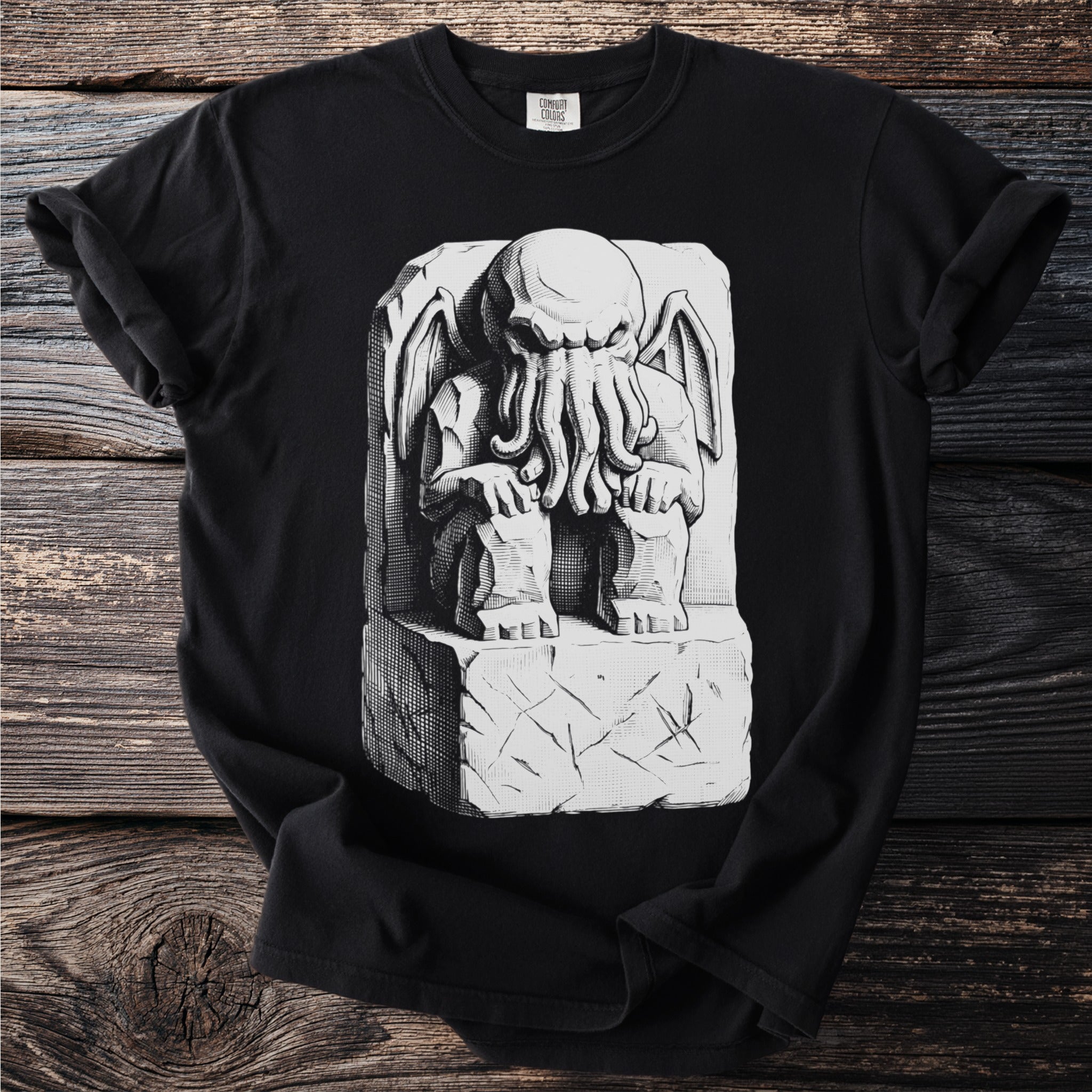 Black t-shirt with a monochromatic illustration of a tentacled creature sitting on a stone block.