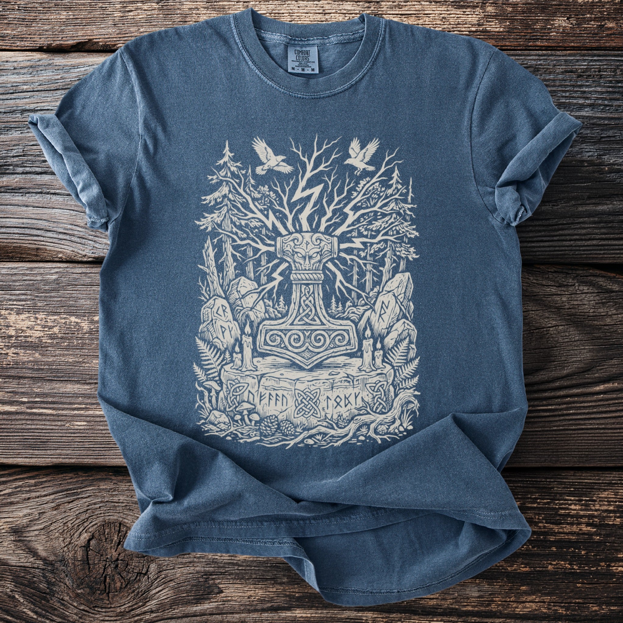 Blue t-shirt featuring a detailed Thor's Hammer design with trees, runes, and birds.