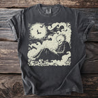 Dark t-shirt with cream-colored graphic of a skeleton sitting on clouds under a full moon with bats.