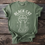 Green t-shirt with white graphic of a cat within a pentagram, text "BLACK CAT witch familiar occult cat".